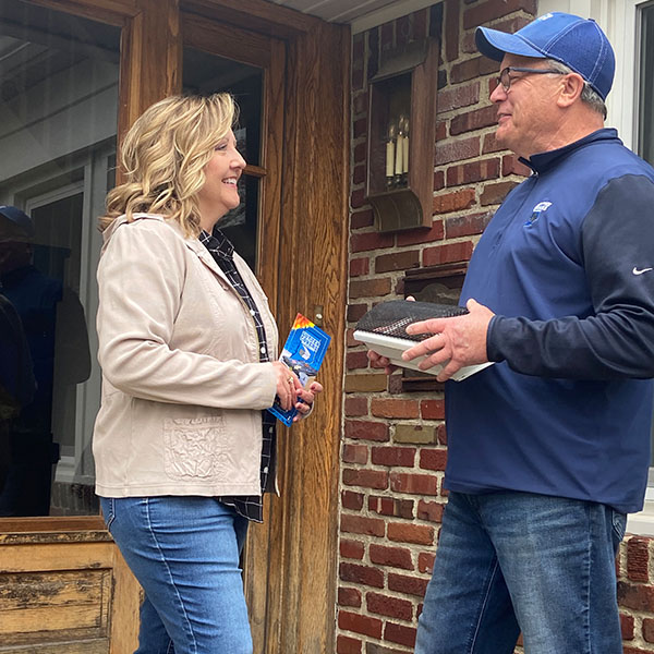 sales man talking to lady outside her house